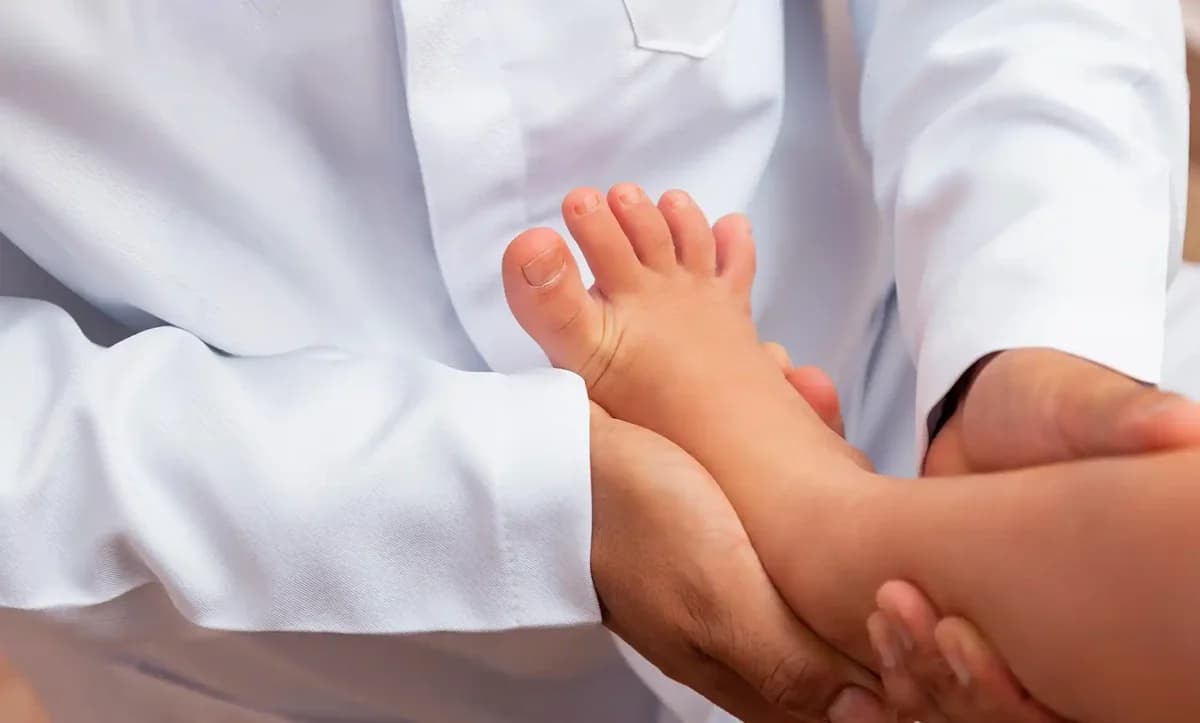 A clinician gently examining a young child's foot